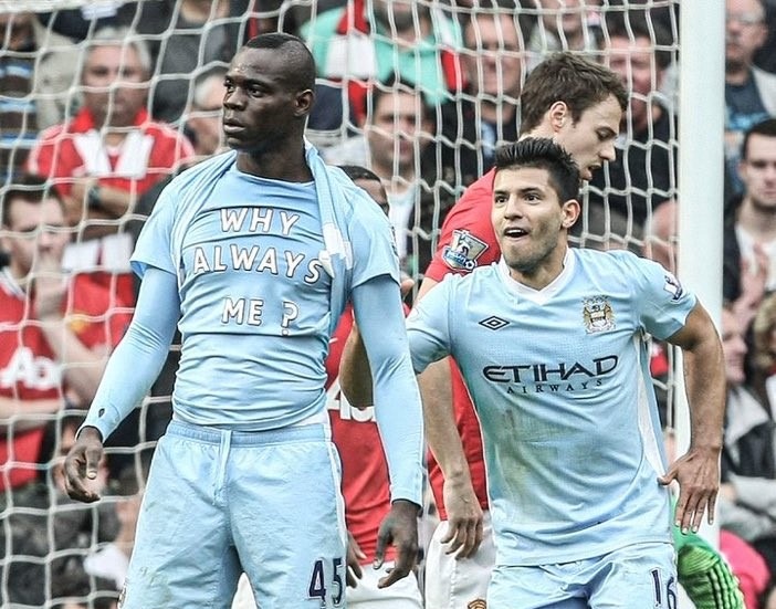Balotelli celebrating with the words "Why Always Me?" written on his shirt as Manchester City beat Manchester United 6-1