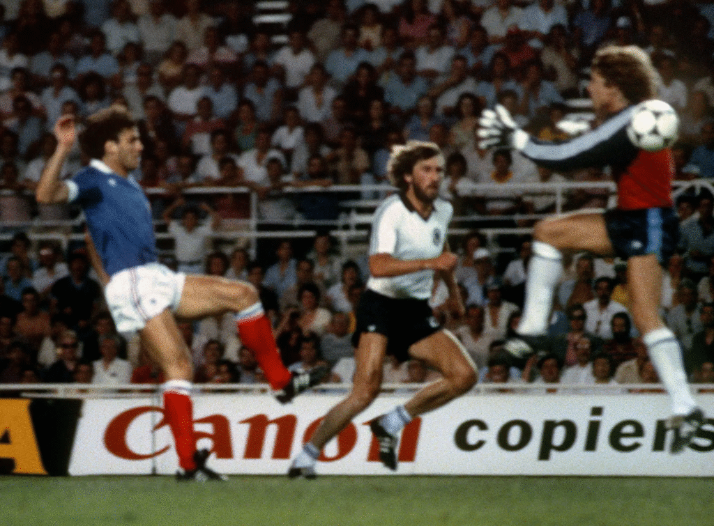 Harald Schumacher leaps past the ball into Patrick Battiston.