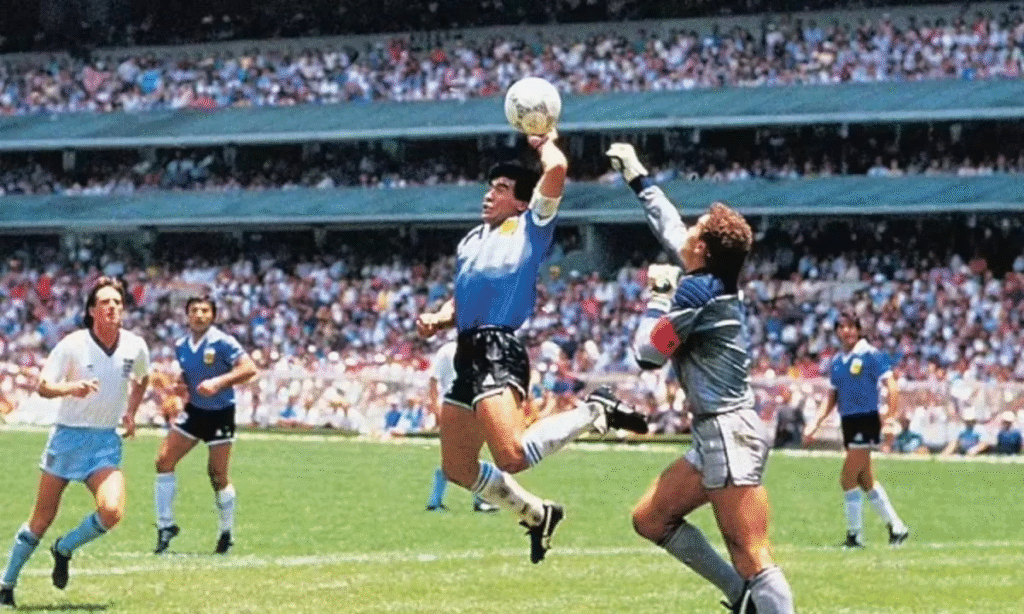 Diego Maradona jumping with his left arm stretched while Peter Shilton jumps with his right hand in the 1986 World Cup quarter final between Argentina and England