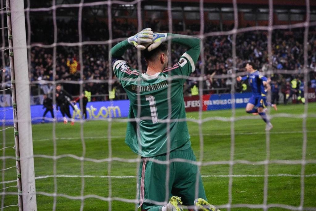 Gigi Donnarumma kneeling, head in hands after Bosnia knocked Italy out of the 2026 FIFA World Cup qualifiers