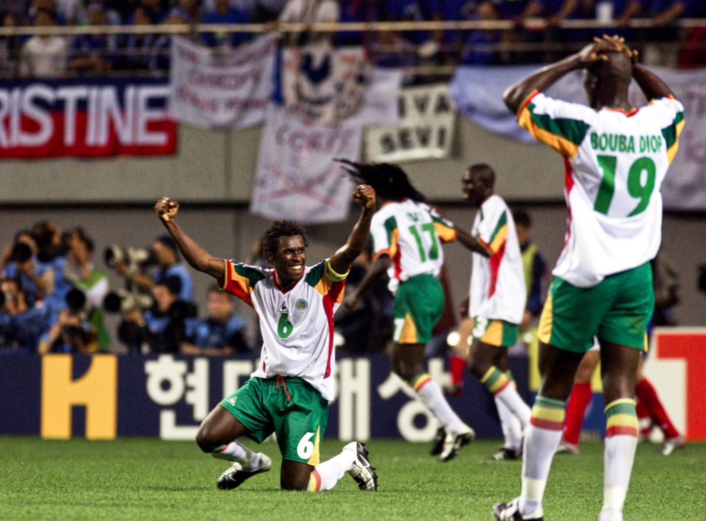 Aliou Cissé and Bouba Diop celebrating after Senegal progressed to the knockout stage against Denmark.