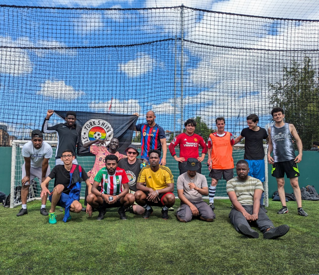 Youth pose for a photo while holding a merch in support of St. Pauli