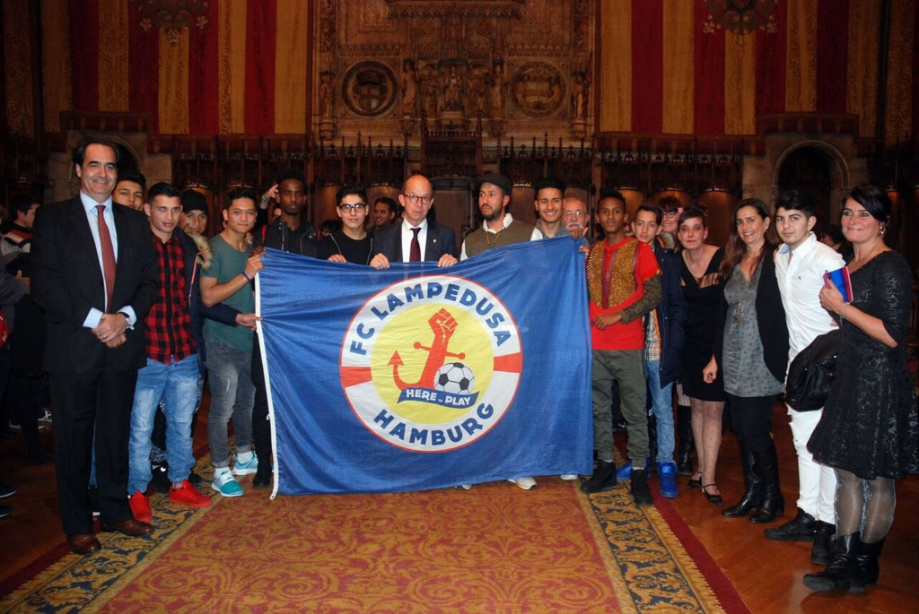 Some members of the society pose with a FC Lampedusa banner