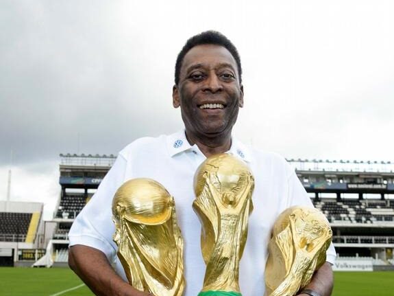 Pele holding three World Cups, the most won by any player in football history.