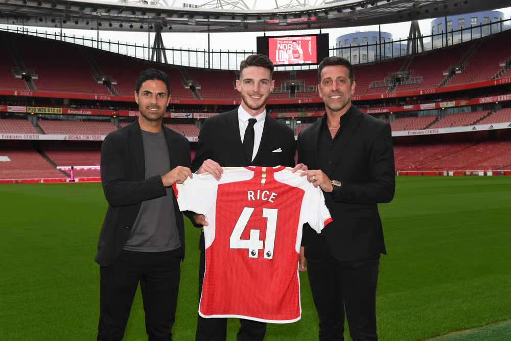 Declan Rice poses with his Arsenal jersey alongside Mikel Arteta and Edu Gaspar