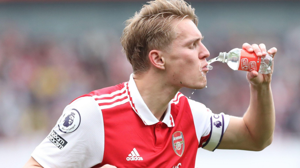 Arsenal captain Martin Ødegaard drinking from a water bottle during a Premier League match