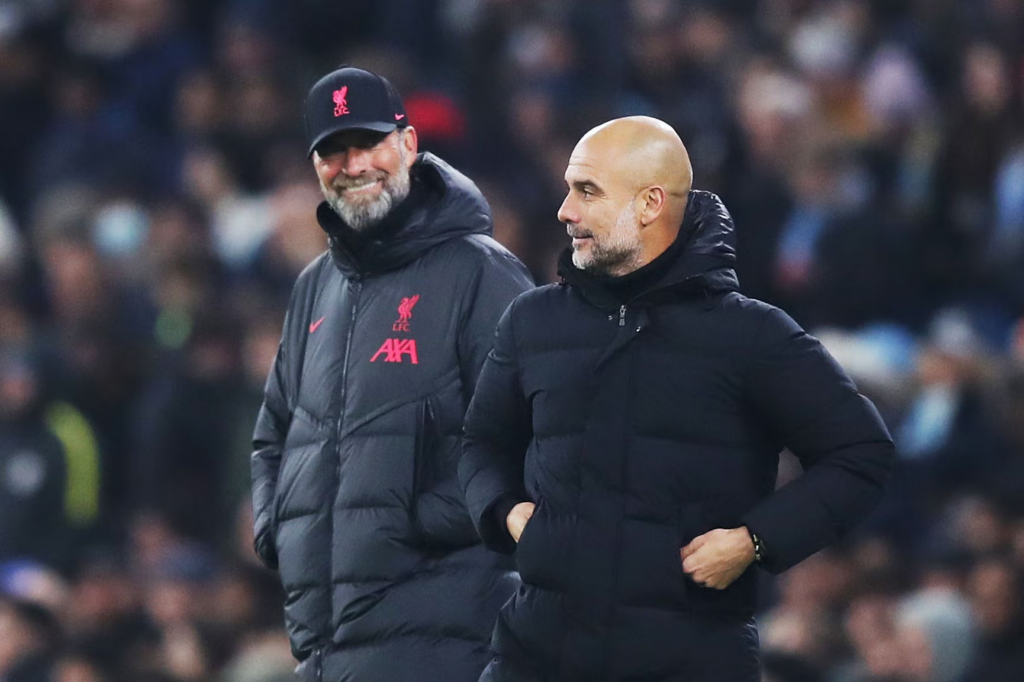 Jürgen Klopp looks on at Pep Guardiola during a Premier League match at The Etihad