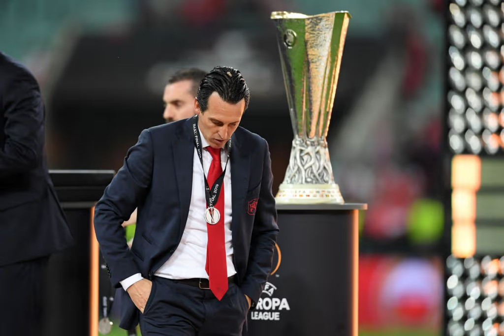 Arsenal manager Emery walks past the Europa League trophy after losing the 2019 Final to Chelsea