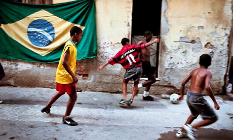 Young boys play football across tarred streets in Brazil's favela