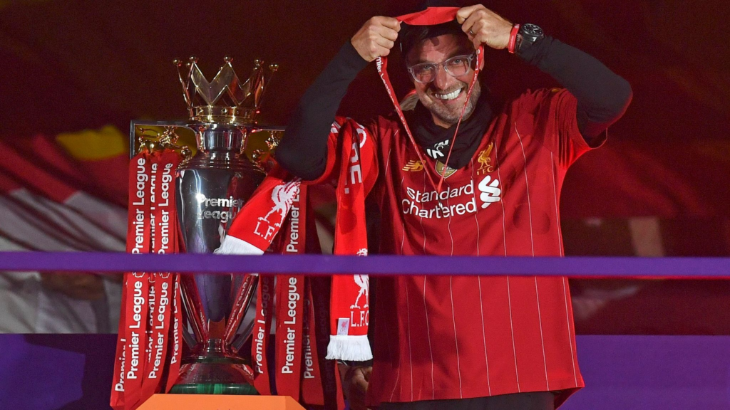 Jürgen Klopp puts on his winner's medal after winning the Premier League title with Liverpool in 2020