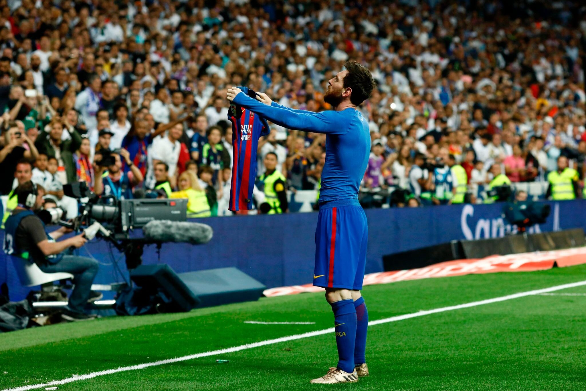 Lionel Messi holds his jersey to celebrate his goal.